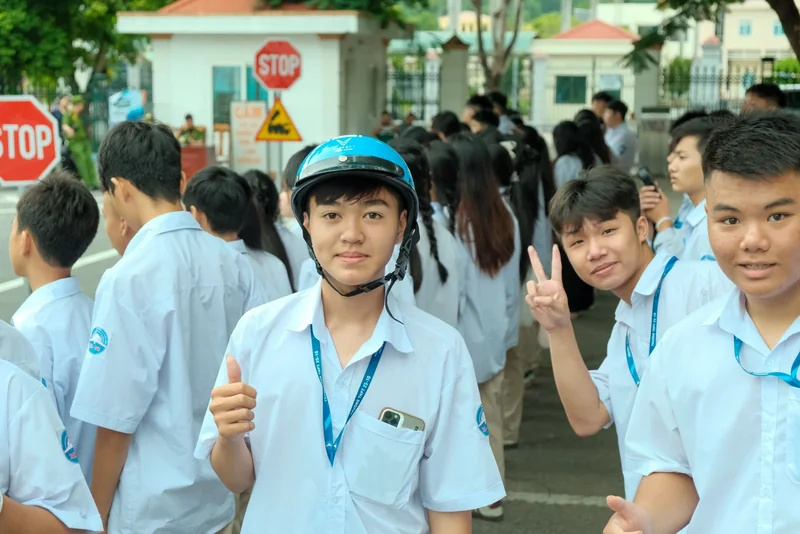 Nhóm học sinh tham gia hoạt động, một em đội mũ bảo hiểm màu xanh mang nhận diện Tiến Cảnh.