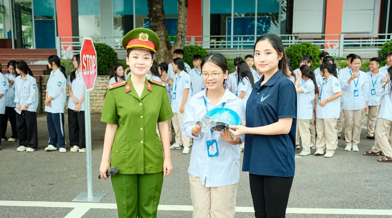 Nhân viên Tiến Cảnh cùng cán bộ công an và học sinh bên chiếc mũ bảo hiểm xanh.